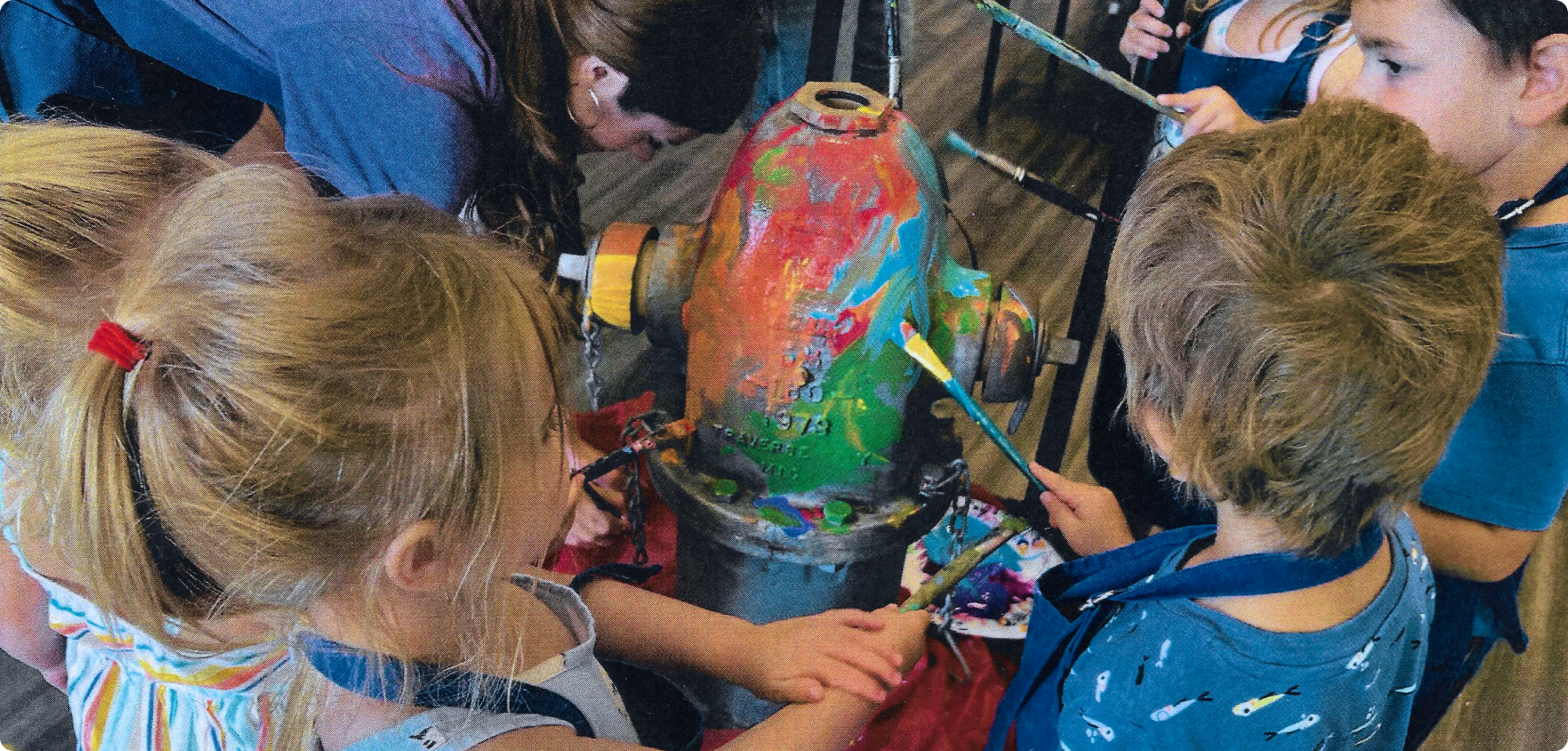 Children at the Jackson School of the Arts painting the fire hydrants.